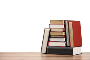 Many old books on wooden table against white background