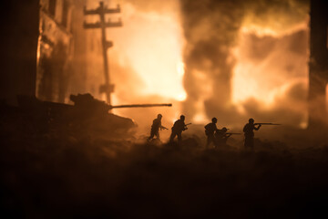 War Concept. Military silhouettes fighting scene on war fog sky background, World War Soldiers Silhouette Below Cloudy Skyline At night. Battle in ruined city.