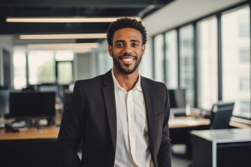 Fototapeta premium Smiling portrait of a young African American businessman in a modern business office in new york