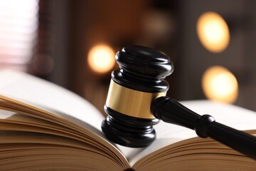 Judge's gavel on book against blurred background, closeup