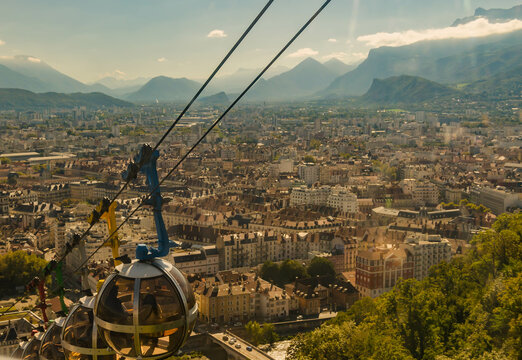 Cabine de t&eacute;l&eacute;ph&eacute;rique survolant la ville et les montagnes