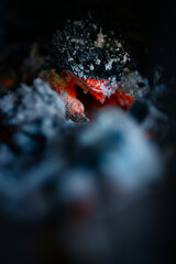 Smoldering embers in a campfire close-up, natural abstract background.