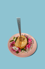 Sandwich with white spring flowers and fork on blue background with copy space.