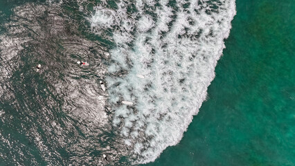 Aerial shot of surfers catching waves along Sri Lanka’s tropical coast, popular destination for surf lovers