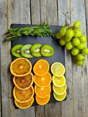 Top view of various citrus fruits arranged on a granite cutting board