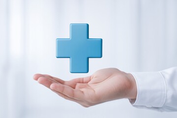 A hand holds a 3D blue medical cross symbol, representing healthcare, support, and assistance in a modern, light-filled environment.