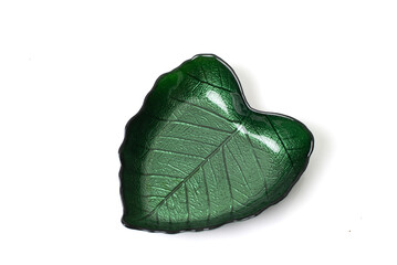 Green glass bowl shaped like a leaf with detailed veins, isolated on white background. Elegant tableware with a nature-inspired design.