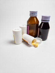 Variety of Medicines Pills Capsules and Syrup Bottles on White background