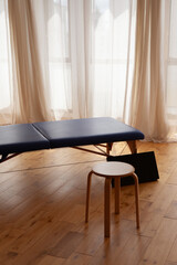 Table de massage en intérieur avec jeu d'ombre de lumière Parquet en Bois et Rideau de voilage