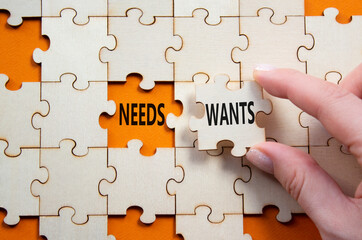 Fototapeta premium Wants and Needs symbol. Concept word Wants and Needs on wooden blocks. Businessman hand. Beautiful orange background. Business and Wants and Needs concept. Copy space