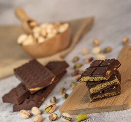 Gourmet chocolate mixed with crunchy kadaif pistachio pieces is beautifully presented on a wooden board, making a perfect treat in Dubai's culinary scene.