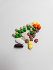 Assorted colorful pills and capsules on a white background