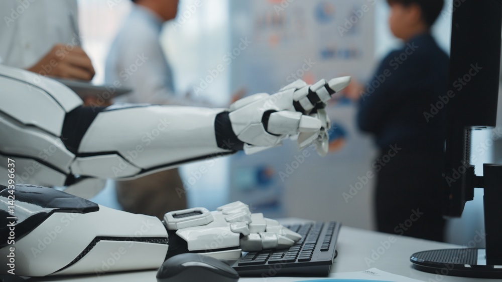 Poster robotic arm interacting with computer keyboard in modern office environment with professionals engag