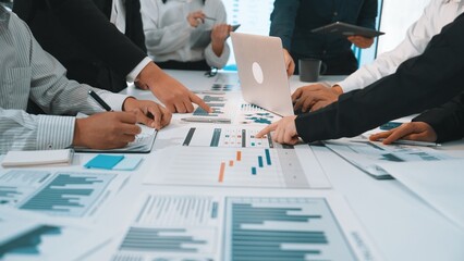 A dynamic business meeting scene showing professionals engaged in detailed analysis of charts and graphs, emphasizing collaboration and strategic planning. SACTR