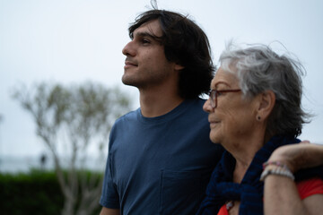 Fototapeta premium Grandson showing respect and love for grandmother on boardwalk