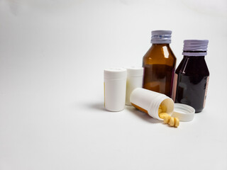 Medicine bottles and pills on white background