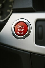 Red engine start stop button on car dashboard