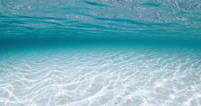 Transparent clear ocean with white sand underwater, tropical sea with waves on surface