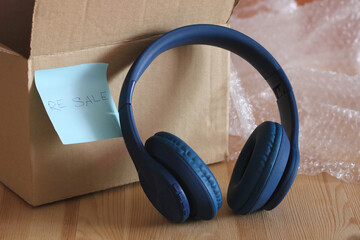 Blue wireless headphones are being prepared for resale and shipping
