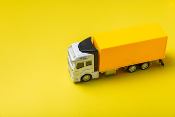 Yellow trucks and cardboard boxes on a bright background. Concept logistics, delivery and transport...