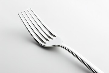 Close-up of a shiny silver fork against a minimalist background