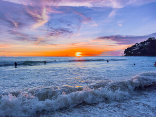 Colourful Sunset at Kamala Beach in Phuket Thailand. Kamala beach on Lovely island of phuket where the waters are turquoise blue, lush green mountains colourful skies