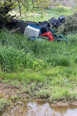 cajas de plásticos tiradas en el campo contaminando el ambiente