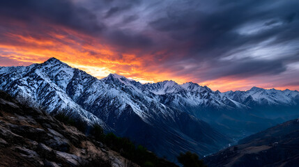 A glowing orange sunset reflecting off the snow-capped mountain peaks, with a calm atmosphere over the valley below.