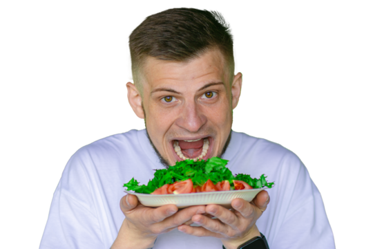 Bearded man in a white t-shirt joyfully pretending to eat a fresh vegetable salad with tomatoes and lettuce,  on a transparent background
