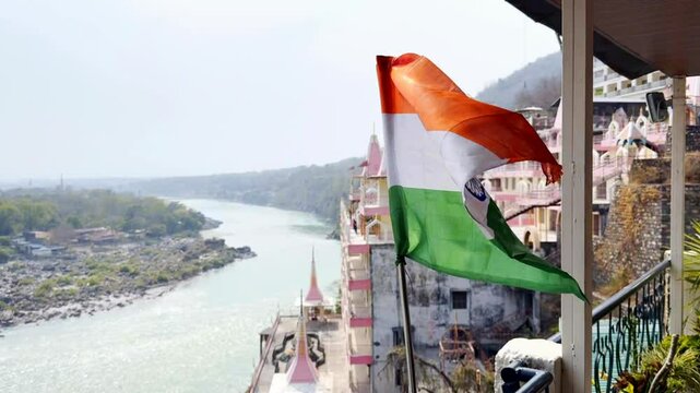 Indian flag waving in slow motion with view of Rishikesh and Ganges river
