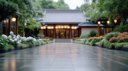 Fototapeta premium Wet stone pathway leads to a traditional Japanese temple illuminated by warm lanterns at twilight.