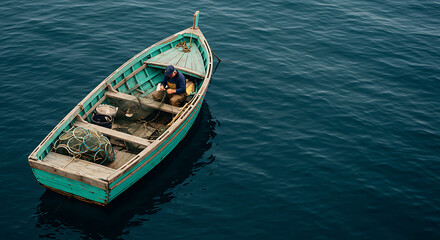 Obraz premium Solitary Fisherman in Small Wooden Boat on Calm Sea