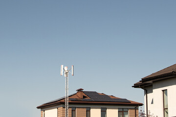 Two buildings display solar panels and a communication tower against a bright blue sky, highlighting advancements in sustainable energy and technology integration in urban areas