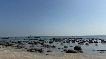 Expansive View of a Rugged Rocky Shoreline at Low Tide Meeting the Calm Blue Water and Clear...