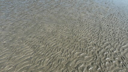 White sand beach texture with abstract blue water waves and natural surface reflection
