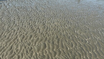 White sand beach texture with abstract blue water waves and natural surface reflection