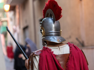 Roman centurion wearing helmet with red plume holding spear during a historical reenactment