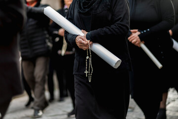 Women holding candles and praying during Good Friday procession