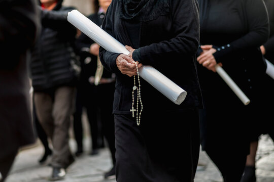 Women holding candles and praying during Good Friday procession - Powered by Adobe