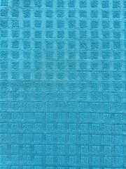 Fototapeta premium Blue textured waffle cotton towel closeup