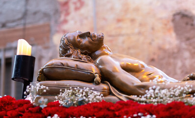 Statue of Jesus Christ lying on a pillow after crucifixion during Holy Week procession