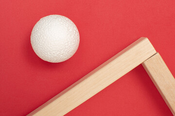 Still life with wooden blocks and a a plastic foam ball on red background	