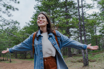 Hiker with open arms breathing fresh air and enjoying freedom in the forest during a hike in nature