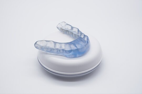 Custom-made dental night guard or mouthguard resting in its case, providing essential protection against teeth grinding and promoting better oral health