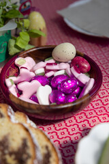 chocolate easter eggs wrapped in violet foil, and various sweets and gummy bears cozonac sweet bread on the side