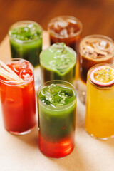 Assortment of non-alcoholic cocktails on bokeh background. Warm tones photo, multi-layered cocktails, drinks in beautiful glasses