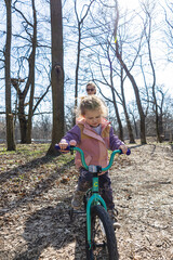 Little Child Riding a Bicycle for the First Time in Park. Happy Kid Learning to Cycle Outdoors
