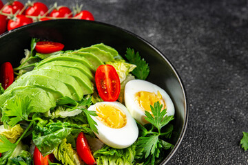 Avocado salad, boiled egg, tomato, green leaf lettuce, vegetable dish fresh delicious gourmet food background on the table rustic food top view copy space keto and paleo diet vegetarian food
