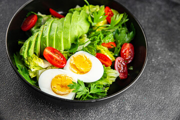 Avocado salad, boiled egg, tomato, green leaf lettuce, vegetable dish fresh delicious gourmet food background on the table rustic food top view copy space keto and paleo diet vegetarian food