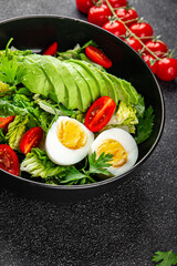 Avocado salad, boiled egg, tomato, green leaf lettuce, vegetable dish fresh delicious gourmet food background on the table rustic food top view copy space keto and paleo diet vegetarian food
